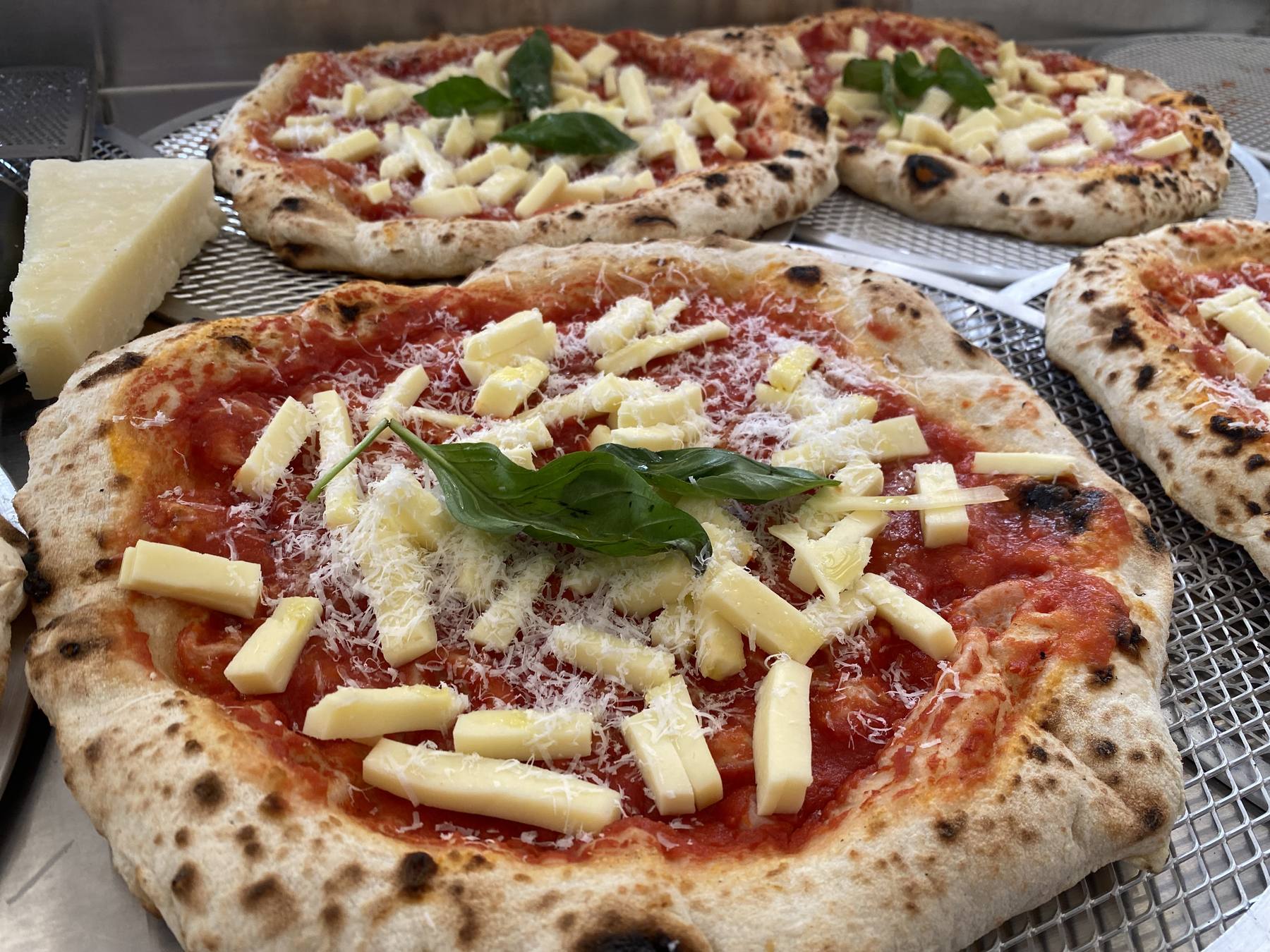 Wood-fired Home Slice pizzas cooling on the rack