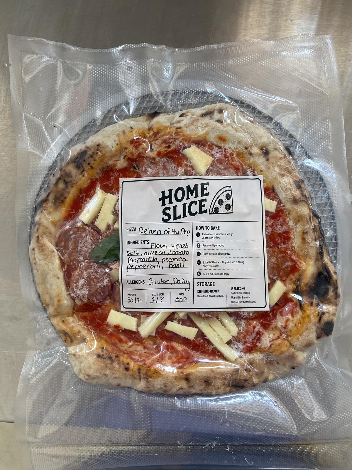 A vac-packed Home Slice pizza with hand-written label